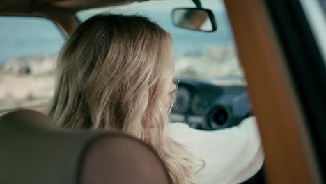 attractive lady sitting automobile looking back with smile close up. summer trip