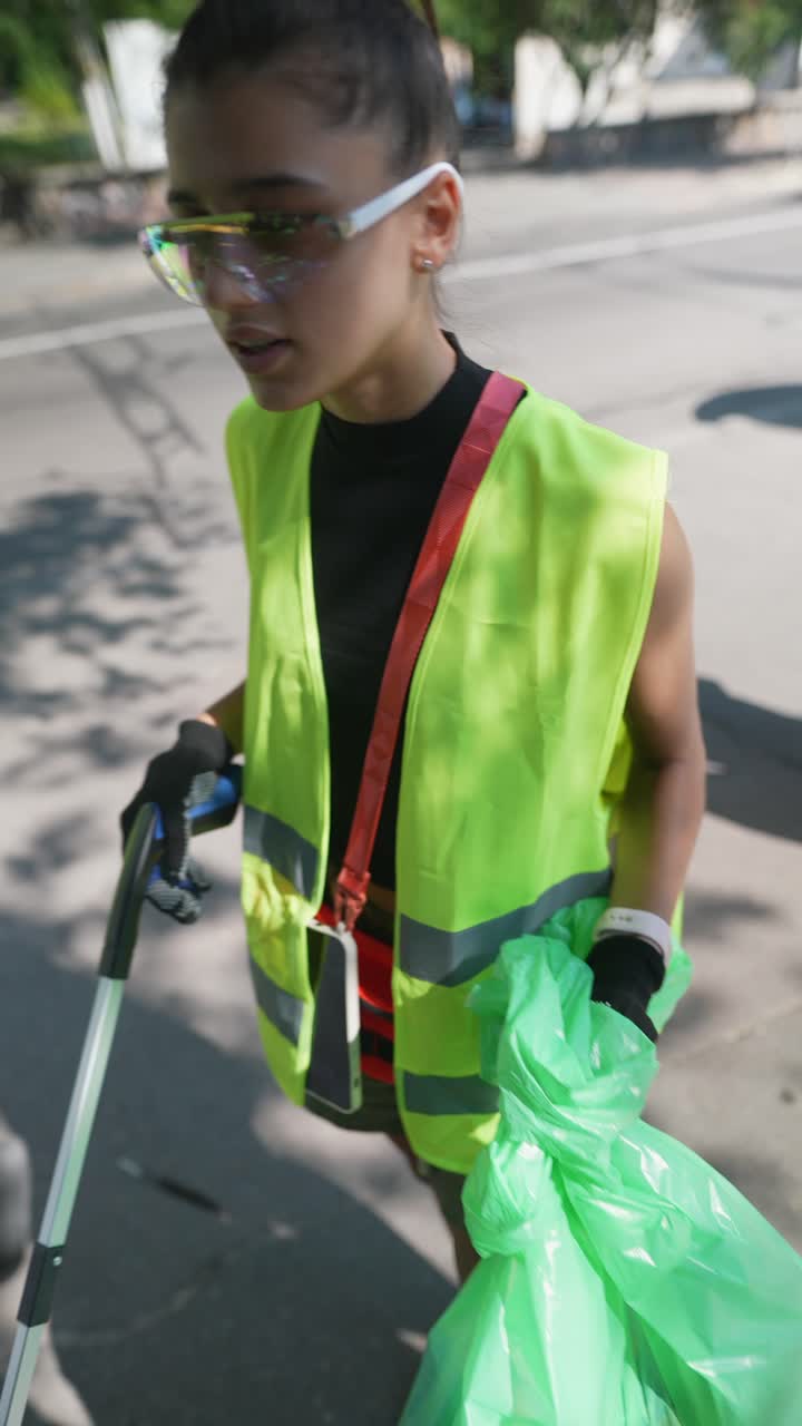 joven limpiando la basura en la calle de la ciudad