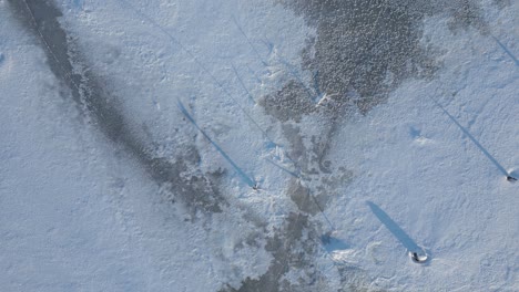 Beautiful-textures,-light-and-shadow-as-we-fly-over-a-frozen-lake