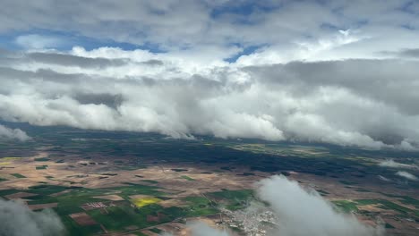 Aerial-view-from-a-cockpit-of-a-cludy-sky-over-green-and-brown-fields-in-central-Spain