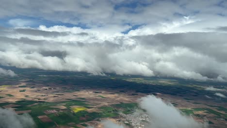 vista aérea desde una cabina de un cielo cludy sobre campos verdes y marrones en el centro de españa