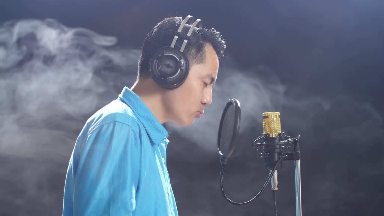 녹음 스튜디오 에서 마이크 로 노래 하는 남자