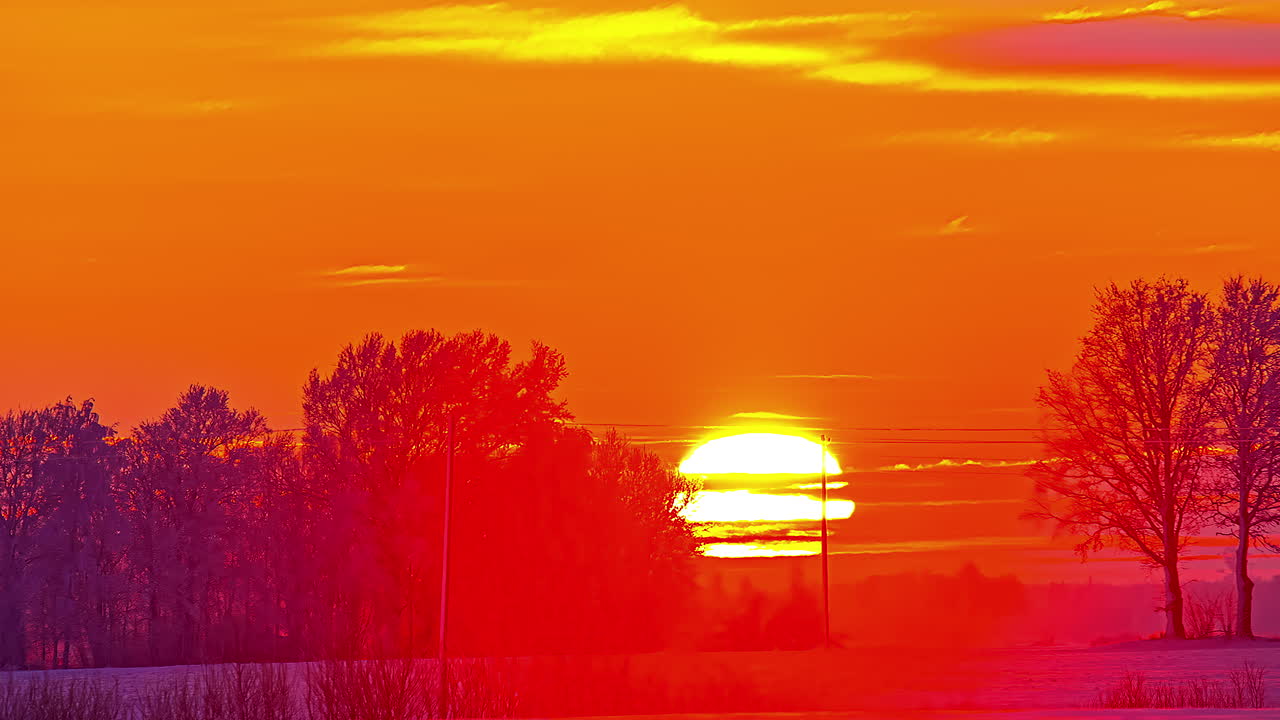 겨울 풍경을 통해 일몰 시간 경과에 빛나는 밝은 태양