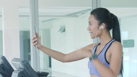 asian girl running on treadmill and talking on the phone