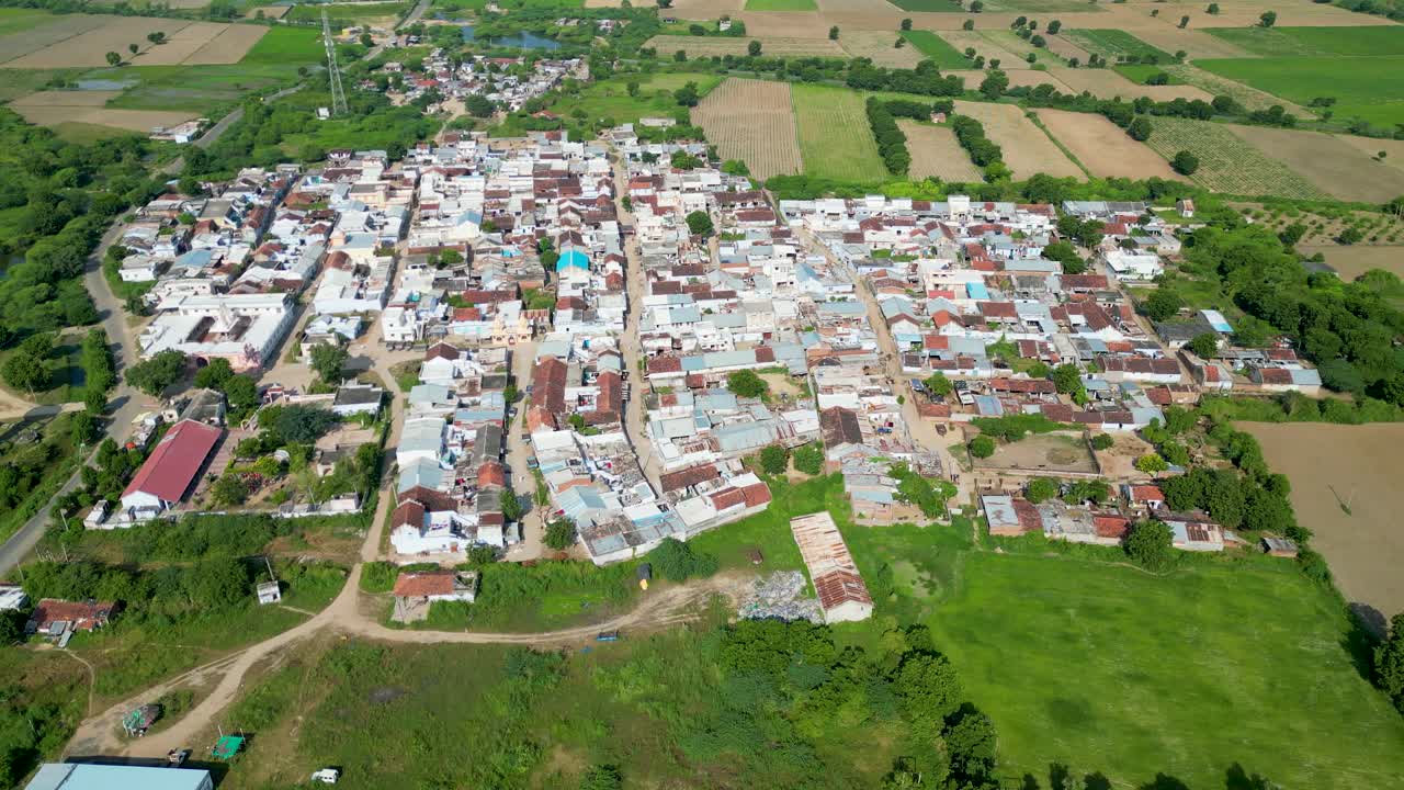 Wide shot of small Indian Village, Country side covered with green farms, small walkways, Gujrat village, rural development