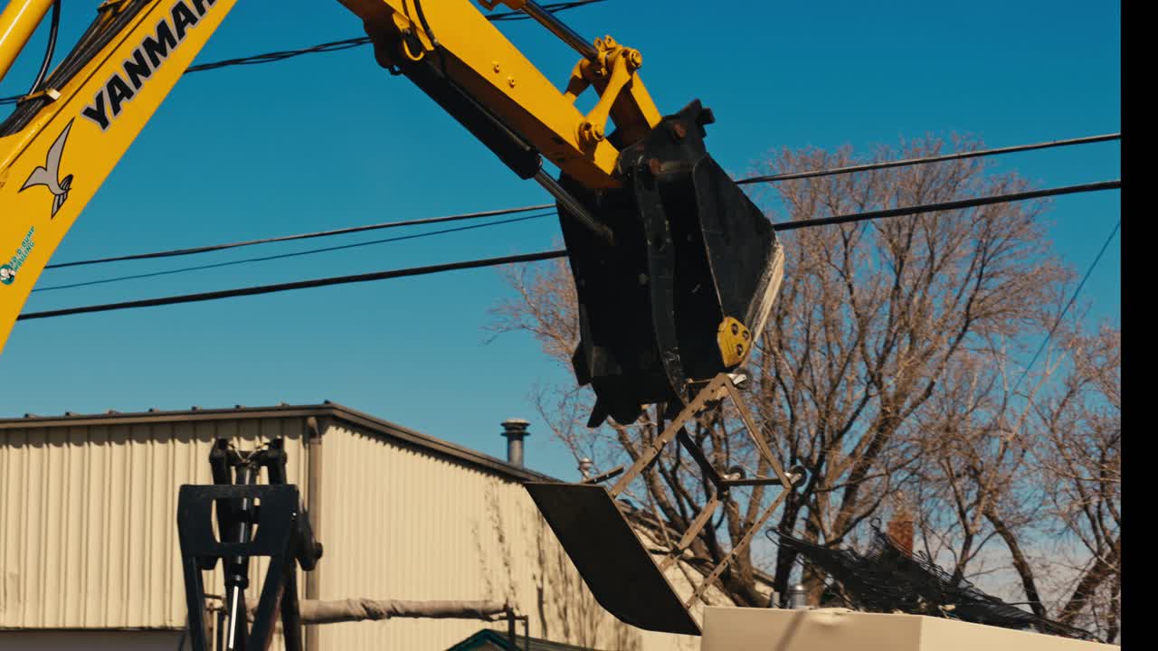 창고 에 있는 쓰레기통 에 쓰레기 를 제거 하는 발굴기