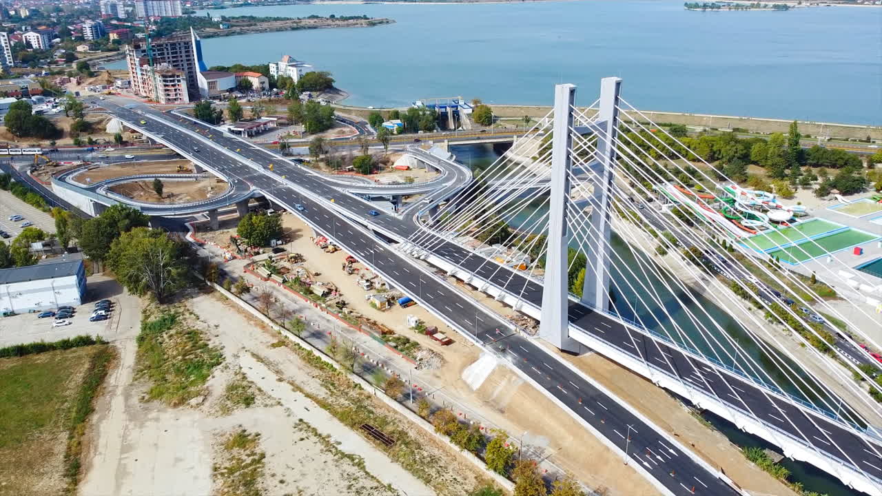 Ciurel passage, bridge over a river with moving cars, recreational complex, lake. View from the drone. Bucharest, Romania
