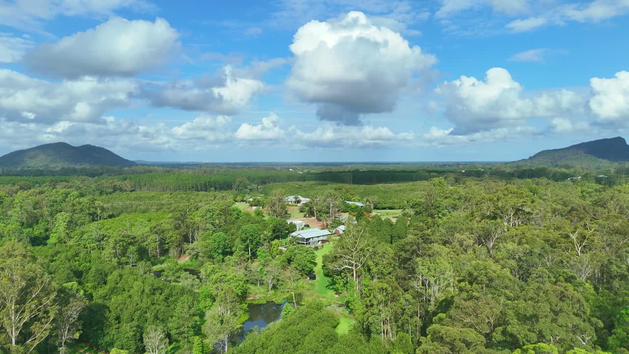 A drone glides toward a large macadamia farm homestead set in the Beerwah Sunshine Coast hinterland