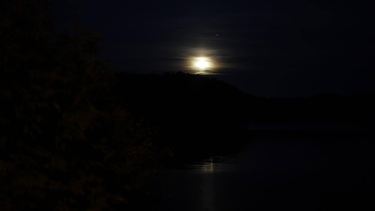 Luna luminosa che sorge sulle colline in Norvegia