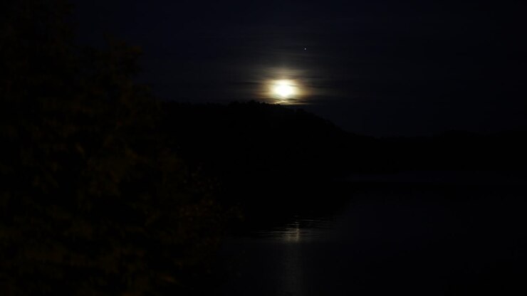 Luna luminosa che sorge sulle colline in Norvegia