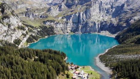 aerial flyover towards the turquoise lake oeschinensee in kandersteg, switzerland on a sunny summer afternoon