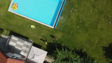 man catching a landing drone with his hands near luxury villa with swimming pool after flight