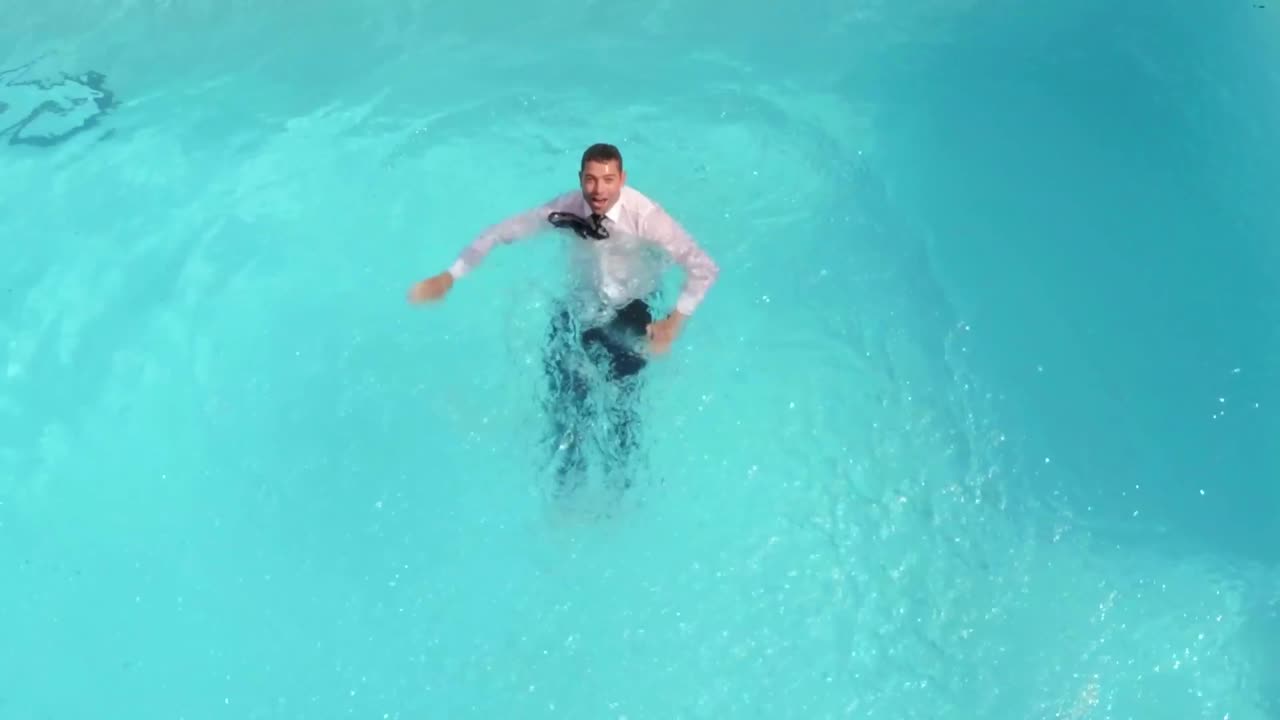 Uomo d'affari vestito che nuota in piscina