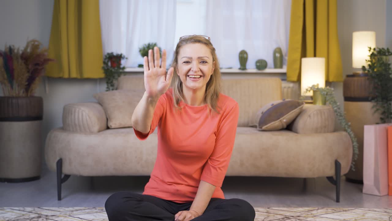 카메라를 향해 손을 흔들고 있는 행복한 여성