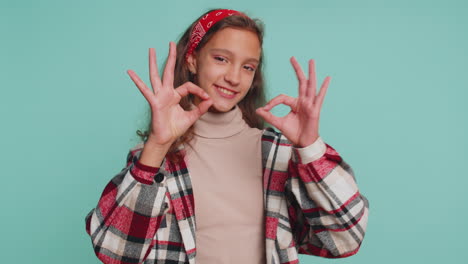 young preteen school girl in shirt looking approvingly at camera showing okey gesture like sign