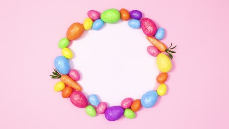 vibrant easter eggs appear around paper card note on pastel pink background. stop motion