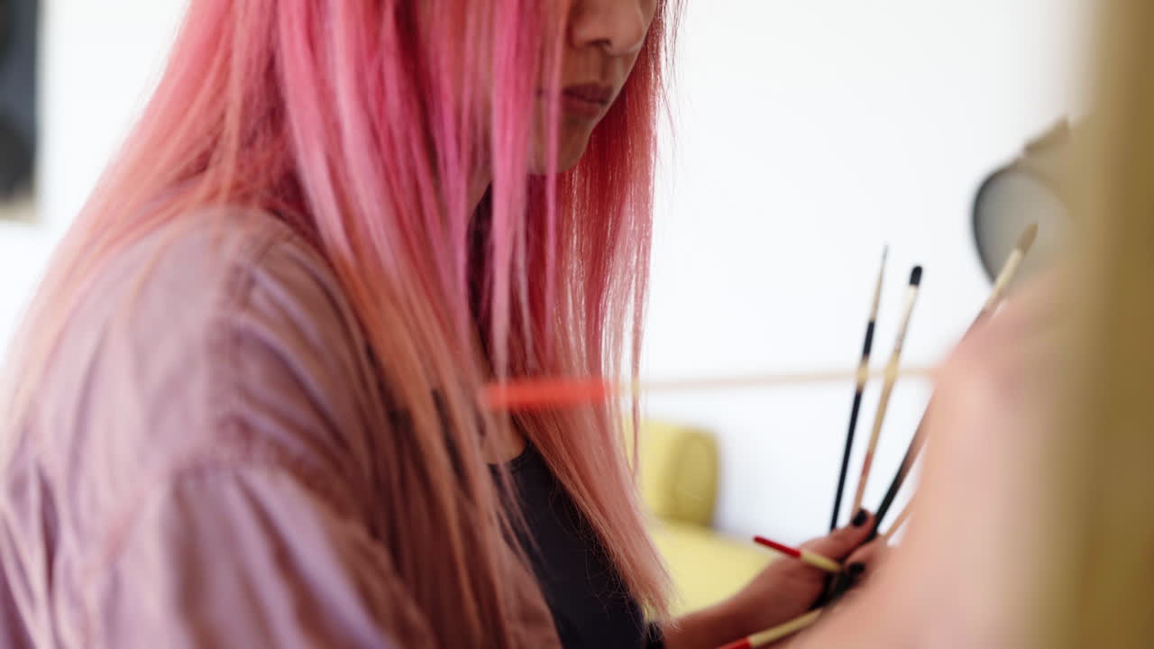 pinceladas detalladas sobre lienzo de un artista coreano de pelo rosa