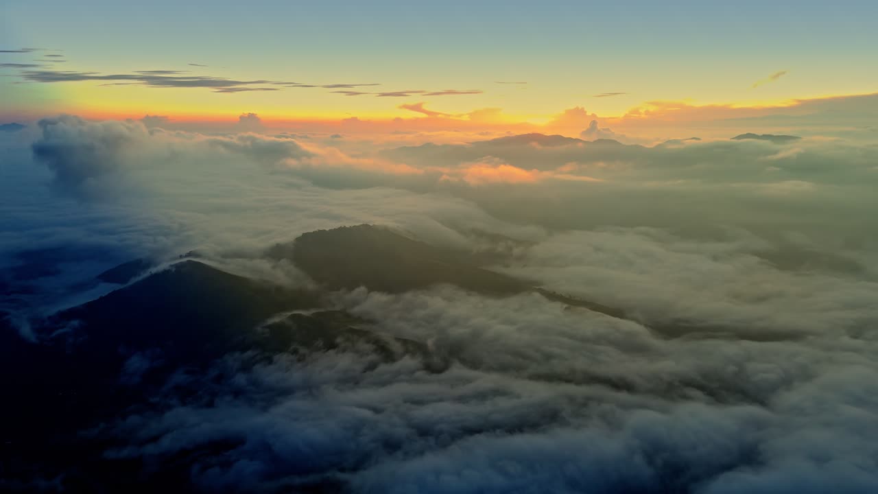 Aerial drone shot of golden sunrise above a sea of clouds over Philippine mountain peaks, creating a dreamy, cinematic, and inspirational natural landscape