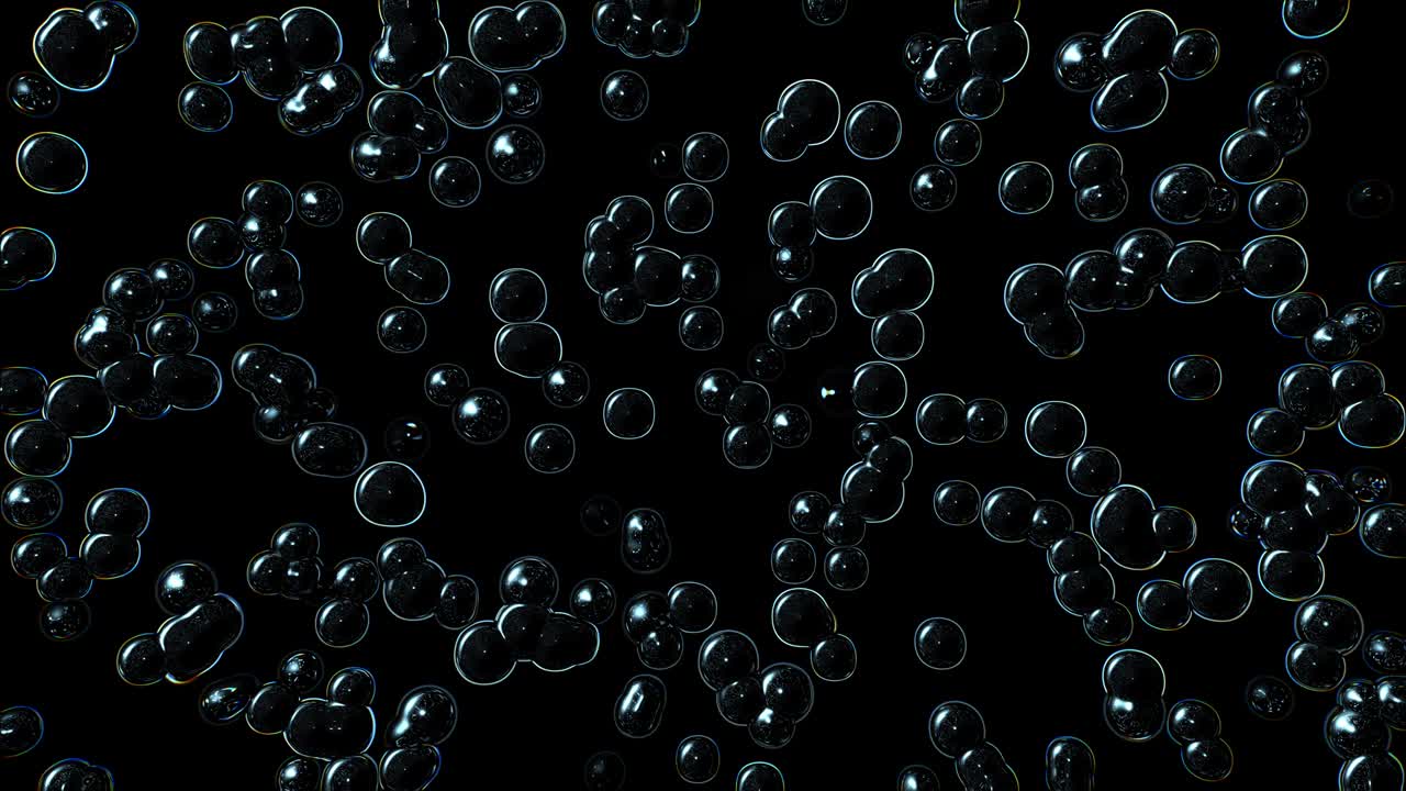 Bubbles multiplying and bursting against a black background