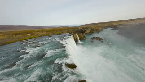 fpv establishing shot of tourists watching the godafoss waterfall in iceland