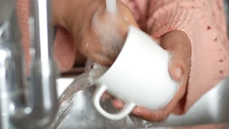 washing a cup in the sink