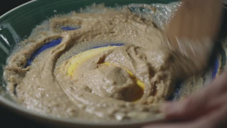 mixing cookie batter by hand using a wooden spoon