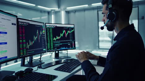 man working on computer with stock market data