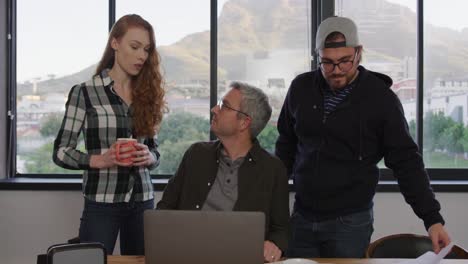 dos hombres y una mujer caucásicos trabajando en una oficina creativa