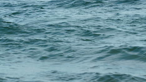 close-up of the sea's surface showing subtle ripples and the reflections of the sky