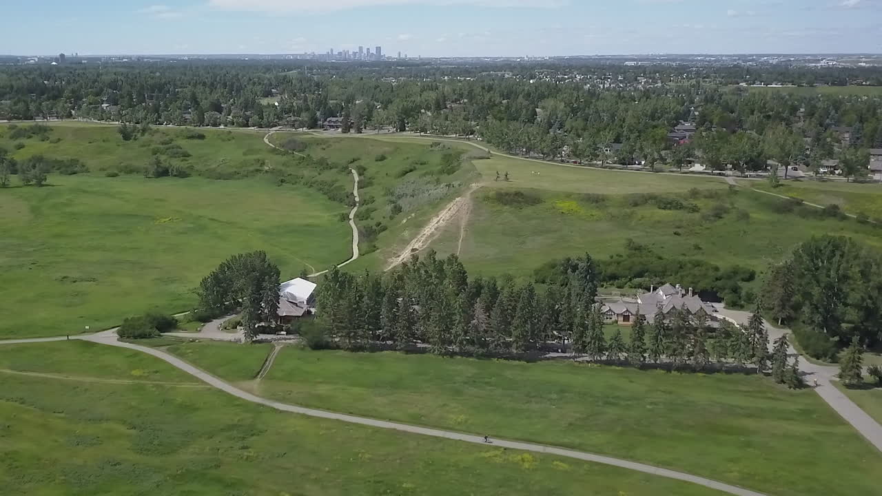 풀이 무성한 녹색 계곡에서 자전거 타는 사람, 먼 거리의 도심