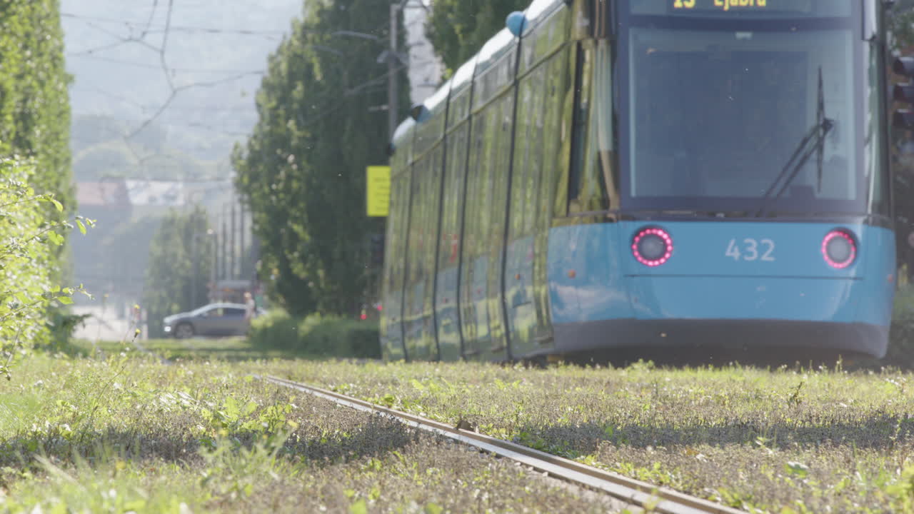 A modern tram travels the buzzing bugs green tram tracks in the centre of Oslo