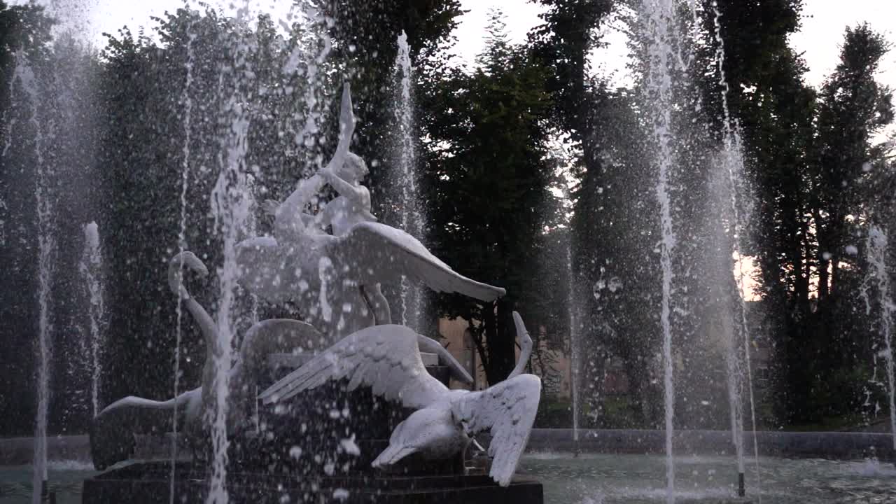 Fontaine dans le parc en soirée. Ralenti