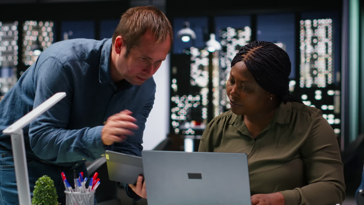 Multiethnic budgeting team reviewing numbers and sales on computer