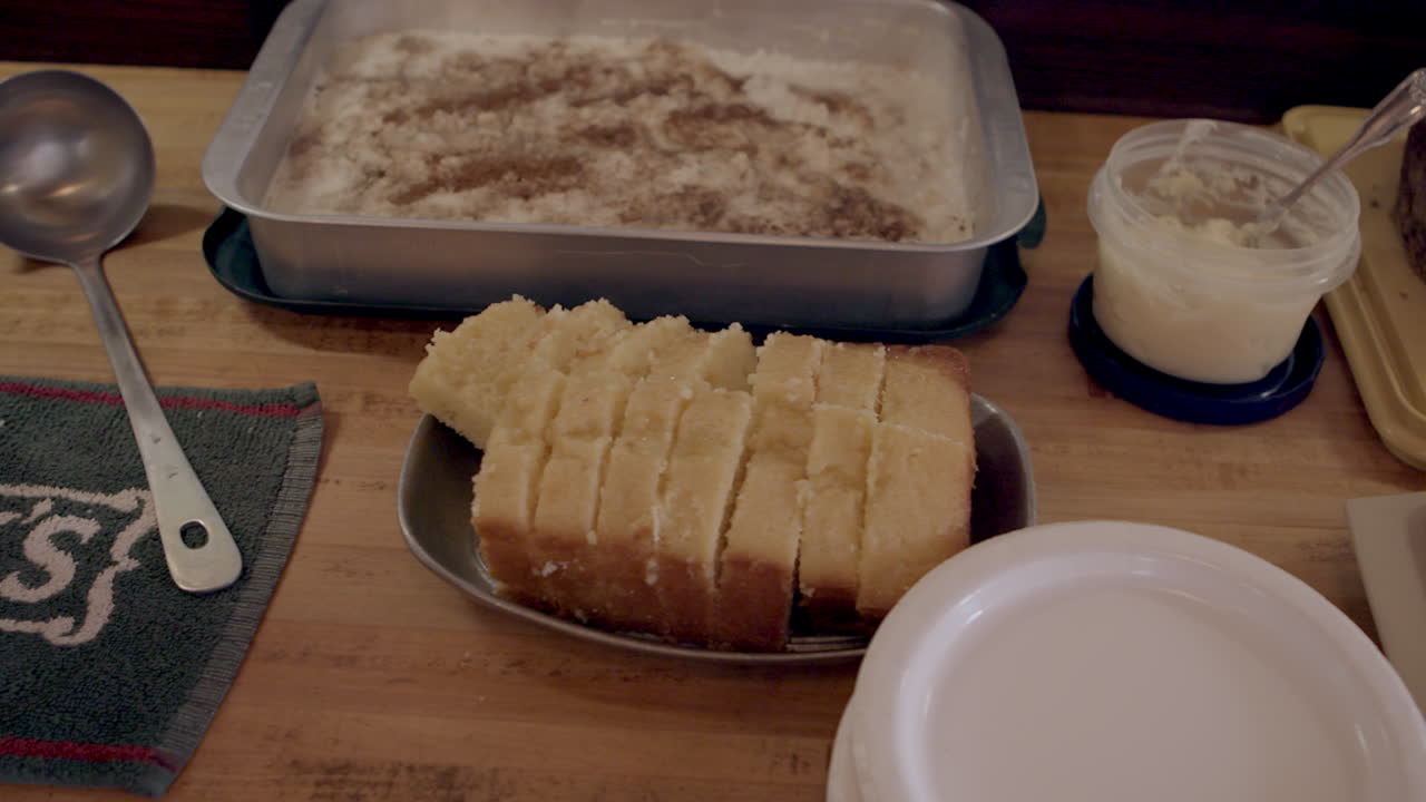 Freshly sliced pound cake on the table with cake and plates and serving spoon
