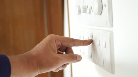 persona que enciende un interruptor de pared