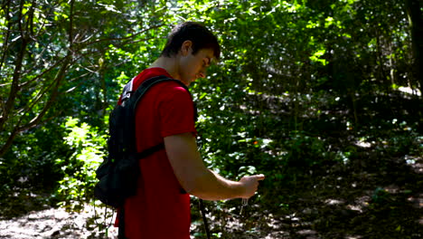 The-hiker-checks-the-direction-on-the-compass-he-has-in-his-hand-and-finds-the-right-hiking-trail