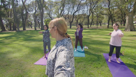 mujeres practicando yoga en un parque