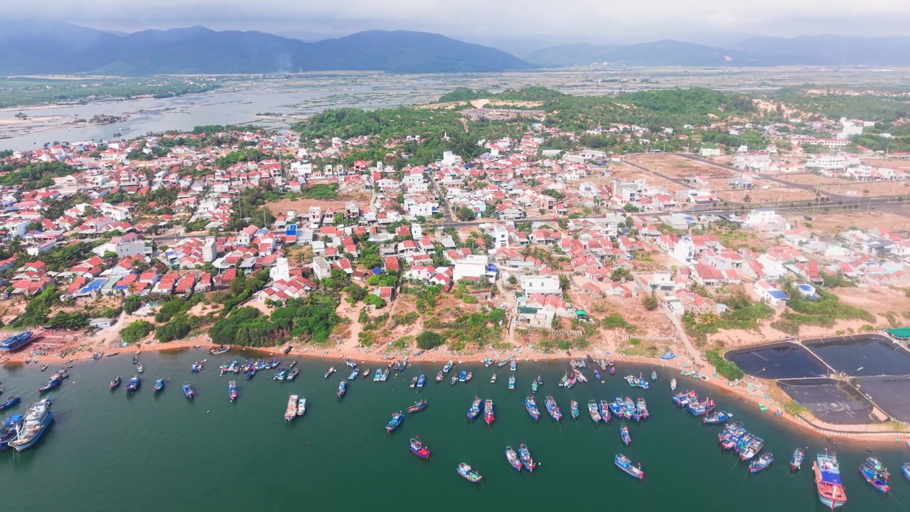 Bien Lo Quang no Vietnã apresenta casas coloridas e barcos de pesca à beira-mar. A vista capta a costa e as montanhas próximas claramente durante o dia.