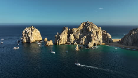 Aerial-view-of-boats-in-front-of-the-cape-at-Cabo-San-Lucas,-sunny-day-in-Mexico