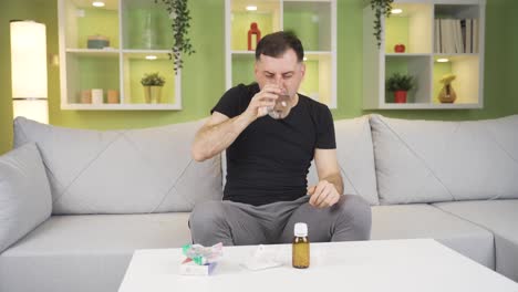el hombre está tosiendo en casa, no puede respirar, como resultado bebe su medicina.