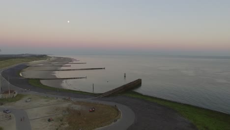 aerial: the pier, beach and lighthouse during sunset near the village westkapelle, the netherlands