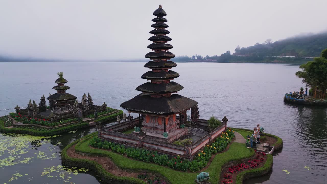 This cinematic drone footage features the peaceful Ulun Danu Beratan Temple on Lake Beratan, with reflections of the temple’s structure shimmering on tranquil waters beneath mountain peaks