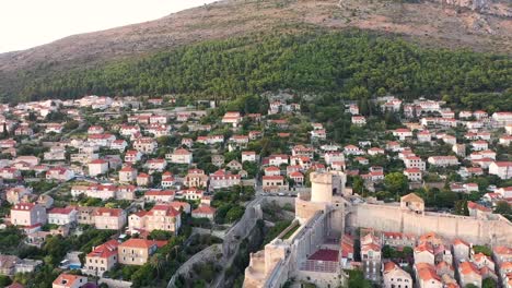 aerial shot of a hill above the great town dubrovnik with a stunning view at sunset