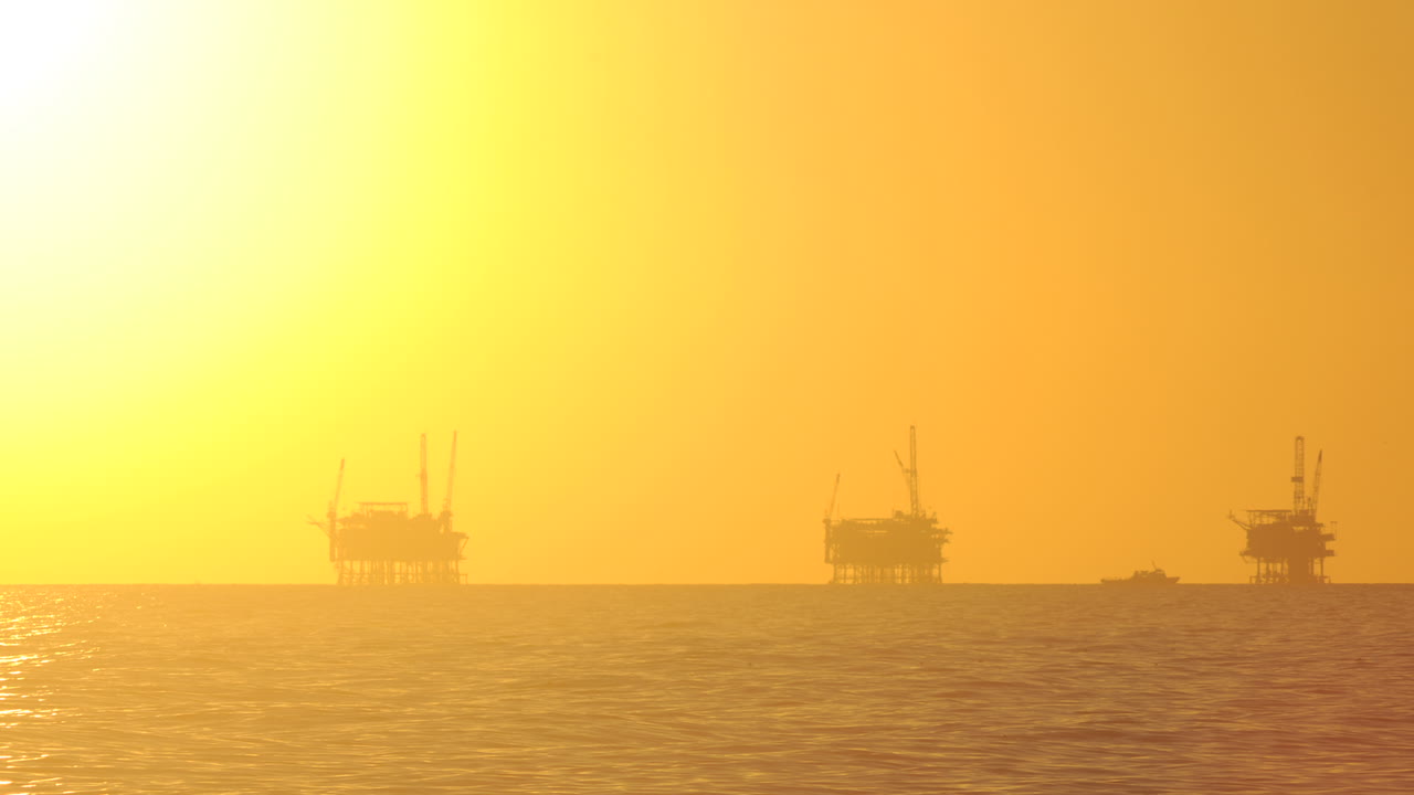 산타바바라 채널 캘리포니아에 있는 3개의 석유 플랫폼 뒤에서 해가 지는 낮부터 밤까지의 시간 경과