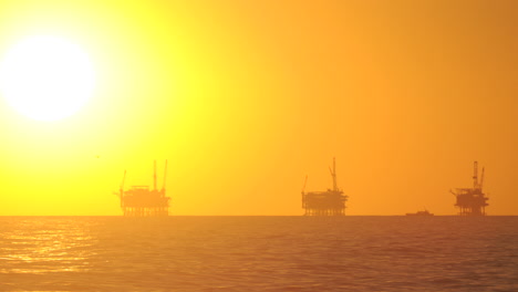 lapso de tiempo de día a noche de la puesta de sol detrás de tres plataformas petroleras en el canal de santa barbara california