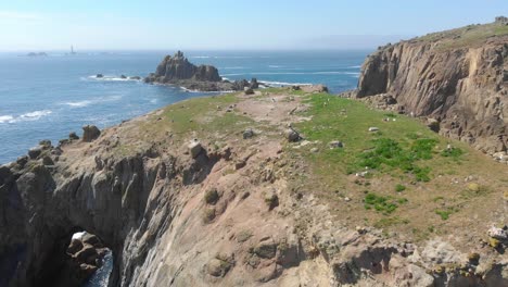 Enys-Dodnan-Arch-along-the-breathtaking-stretch-of-coastline-at-Land's-End,-Cornwall-during-a-warm-sunny-day