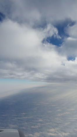view from a plane window of the sky with the wing shot in vertical