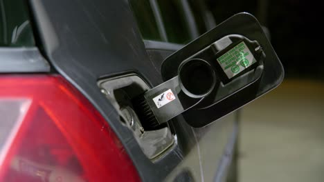 ppening the fuel filler flap in the car on a petrol station at night