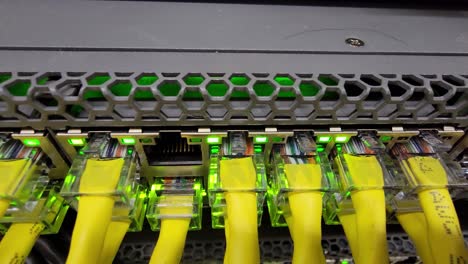 network switch with yellow ethernet cables and flashing lights indicating activity