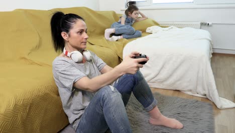 upset daughter annoyed that her mother is playing video games at home near the couch